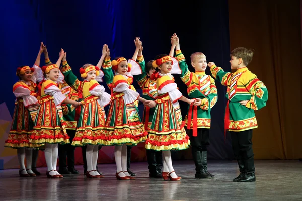 Folk dance - a group of children in folk costumes lined up to \