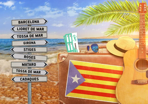Concept of summer traveling with old suitcase and Catalonia town sign with burning sun