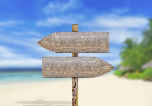 Wooden direction sign on beach