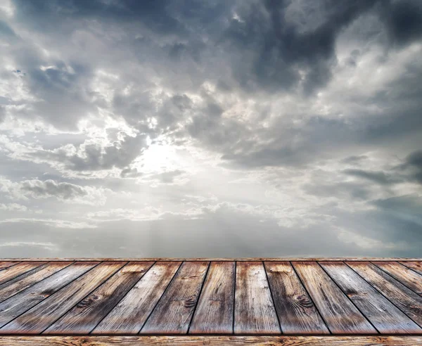 Wooden terrace with storm cloudy sky
