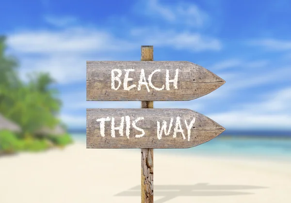 Wooden direction sign with beach this way