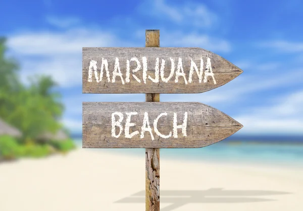 Wooden direction sign with marijuana beach