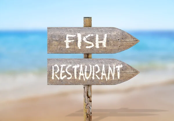 Wooden direction sign with fish restaurant