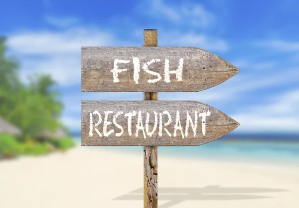 Wooden direction sign with fish restaurant