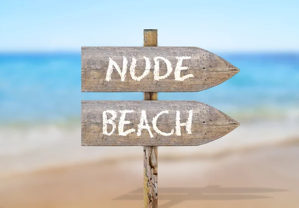 Wooden direction sign with nude beach