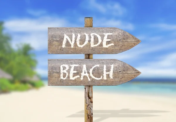 Wooden direction sign with nude beach