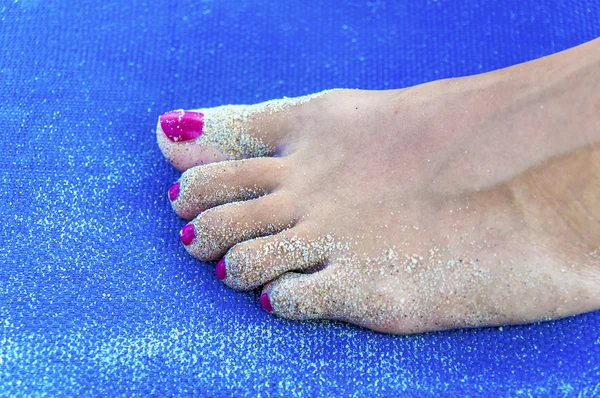 Girl sandy feet on sunbed close