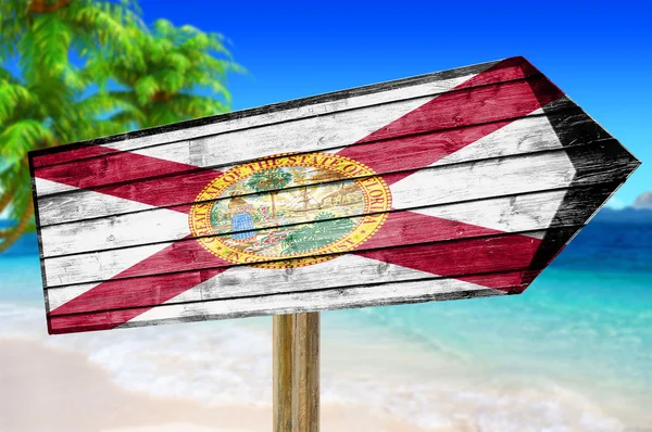 Florida Flag wooden sign on beach background