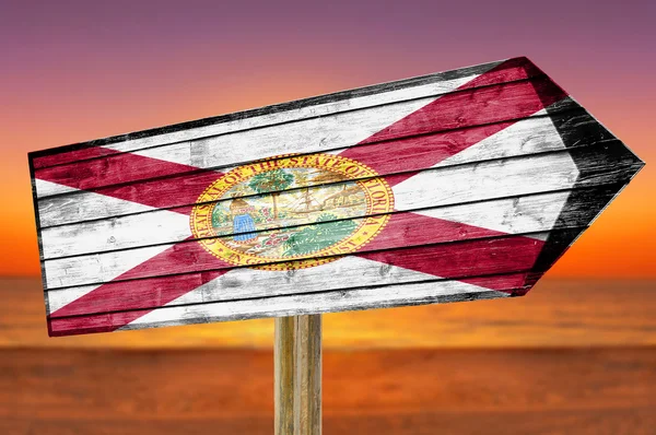 Florida Flag wooden sign on beach background