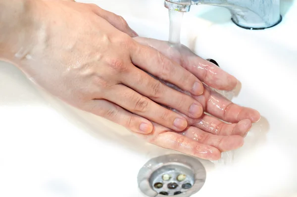 Washing of hands with soap under running water