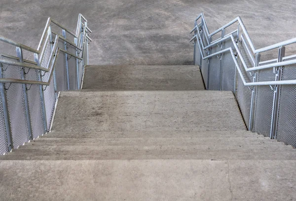 Concrete stairs and metal handrails under the bridge