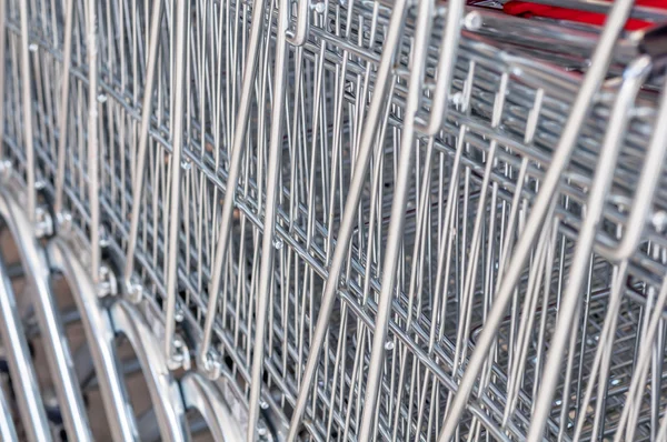 Close Up of The Metal Mesh of Shopping Carts Lined Up in A Row