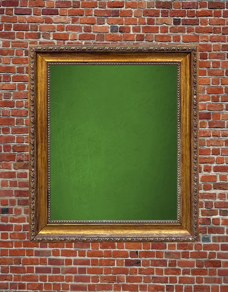 Vintage green chalkboard with wooden frame hanged on brick wall