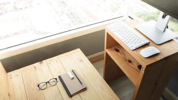 Loft workspace with stationaries on wooden table.