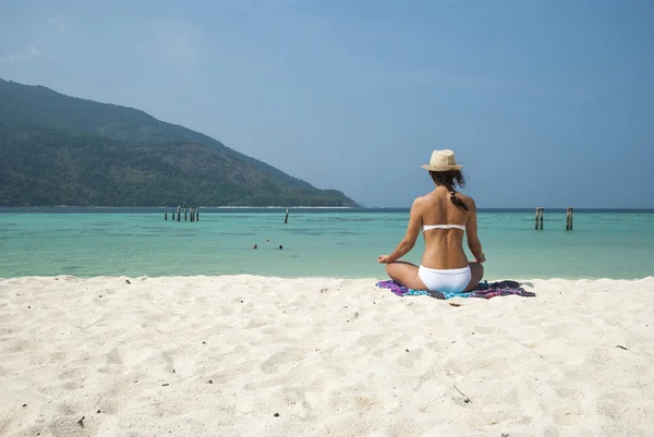 Beach meditation. Woman meditating on beach sitting in lotus pos