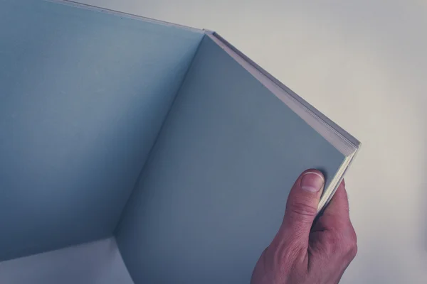 Hands holding open book with blank pages