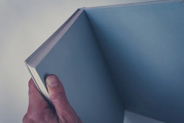 Hands holding open book with blank pages