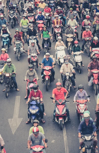 Motorbike traffic in saigon - many scooter drivers , crowded street