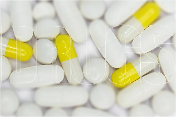 White pills macro / yellow capsules close up