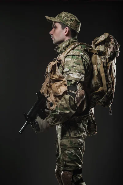 Soldier man hold Machine gun on a  dark background