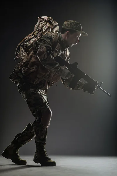 Soldier man hold Machine gun on a  dark background