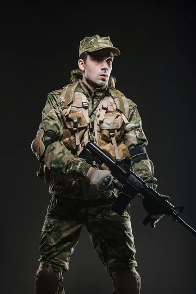 Soldier man hold Machine gun on a  dark background