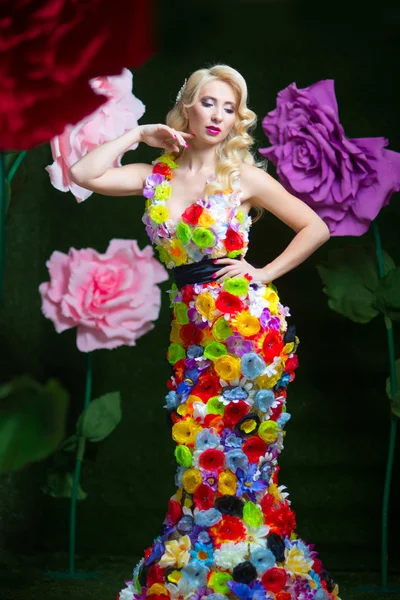 Beautiful woman in dress of flowers on the background of large flowers