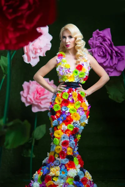 Beautiful woman in dress of flowers on the background of large flowers
