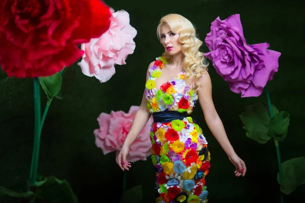 Beautiful woman in dress of flowers on the background of large flowers