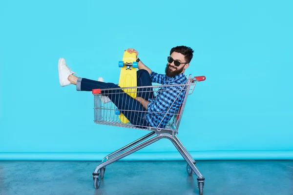 Young man sitting in shopping cart