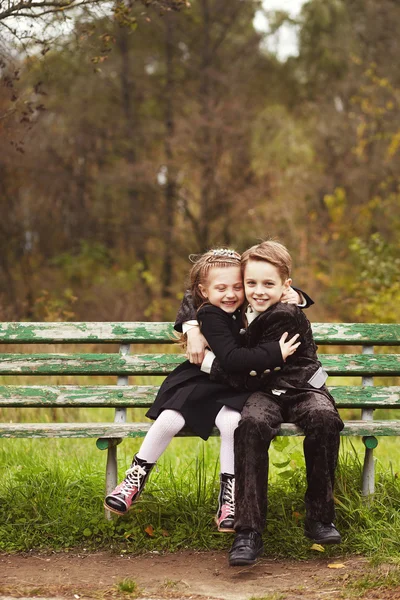 Cute little girl and boy hugging on bench