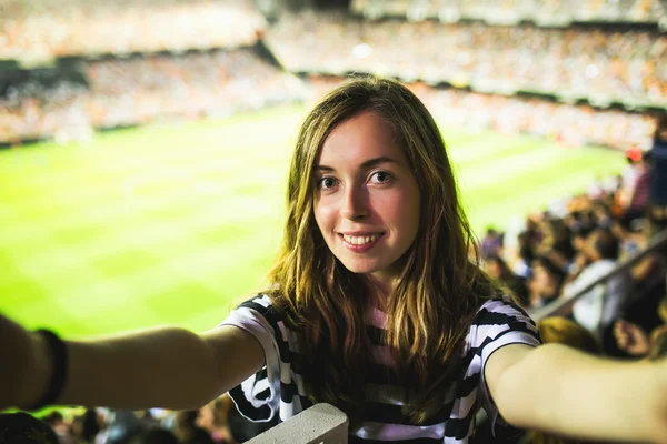 Woman making selfie on football game