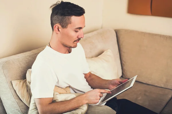 Man relaxing on the sofa with tablet