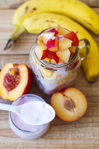 Vertical photo of fruit salad mixed with fresh yogurt, banana