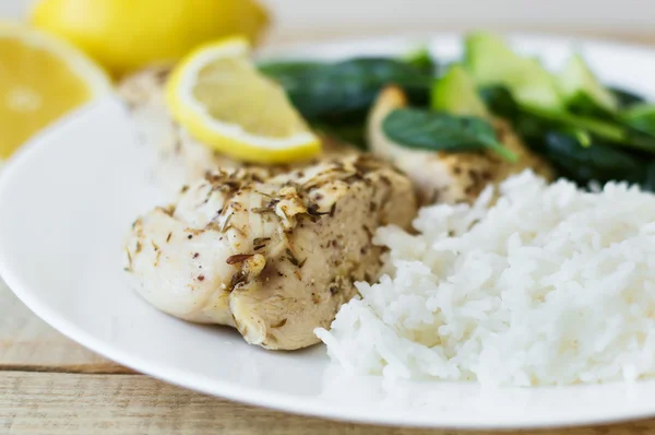 Chicken breasts with thyme, lemon, rice and spinach salad. Healthy and diet eating concept
