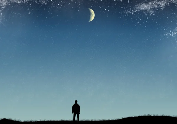 Silhouette of a man on the field with grass, starry sky and moon