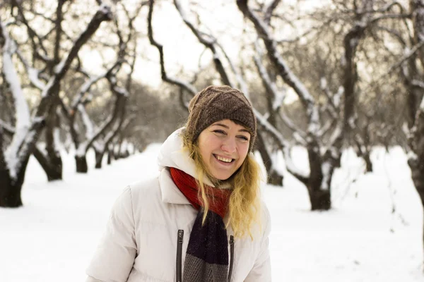 Young beautiful girl close up in winter park enjoys snow fell