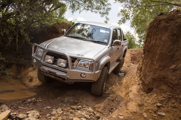 Four-wheel drive vehicle Toyota Hilux is doing off-road.