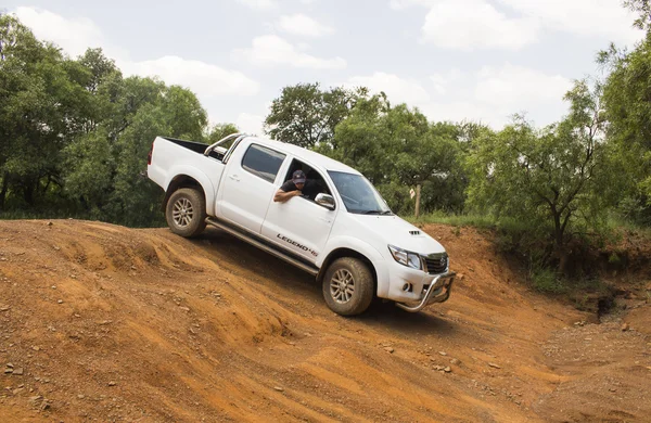 Four-wheel drive vehicle Toyota Hilux Legend 45 is doing off-road trail.