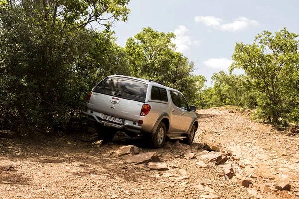 Four-wheel drive vehicle Mitsubishi Triton is doing off-road trail.