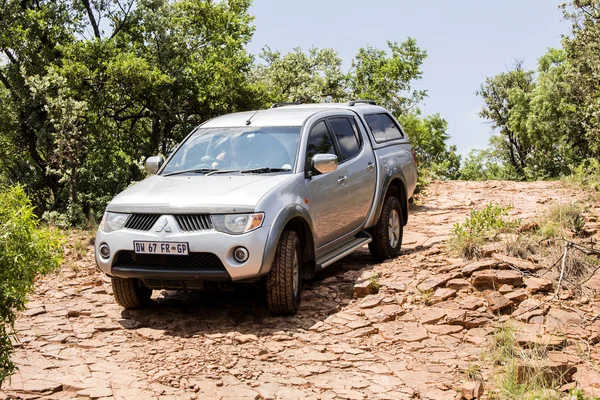 Four-wheel drive vehicle Mitsubishi Triton is doing off-road trail.