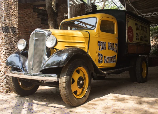 Yellow old model Chevrolet pickup truck in the patio of ancient cafe Tan Malie Se Winkel 1921. Vintage car style.