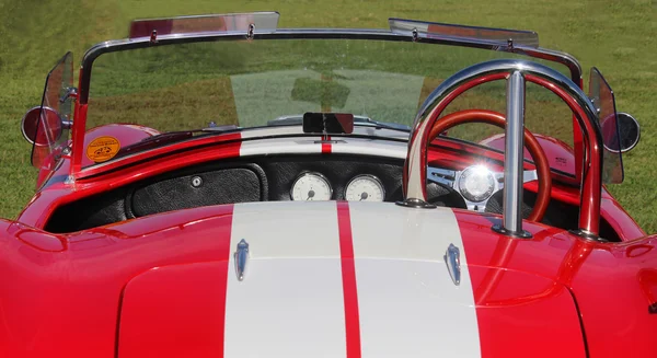 Red dashboard of old model sport car AC Cobra at the festival Highland Gathering. Vintage car style.