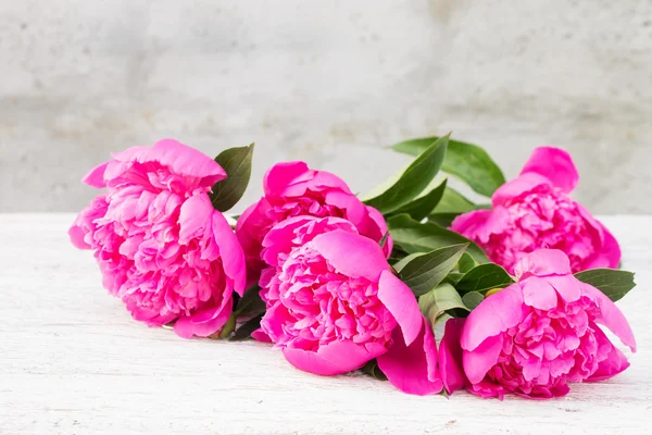 Bouquet of pink peonies on a light blurred background