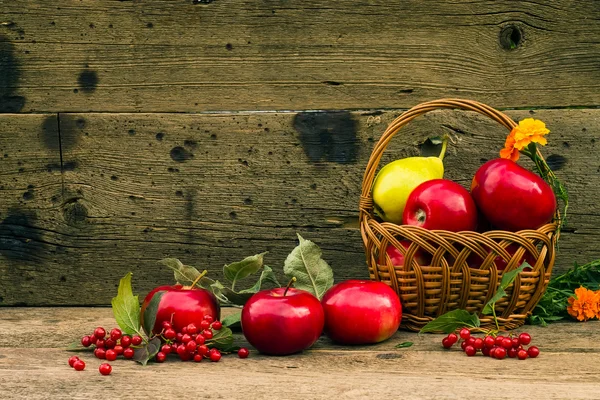 Red apples and yellow pear in a basket