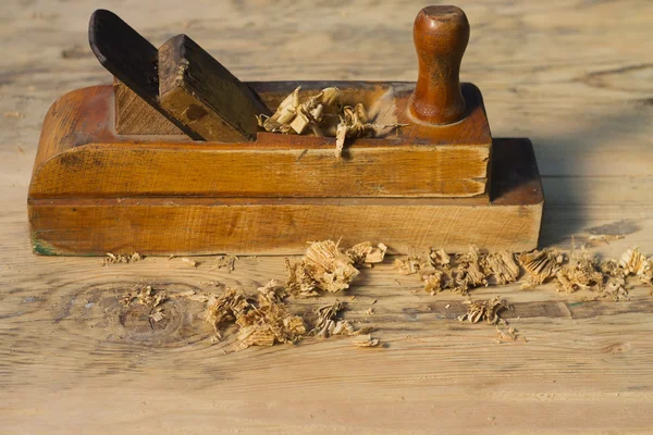 Old  jack-plane  with wood shavings on a wooden surface