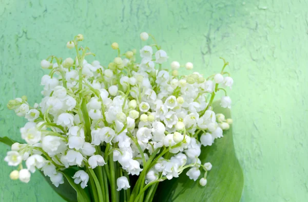 Beautiful lilies of the valley on old wooden background. Bouquet of lilies of the valley