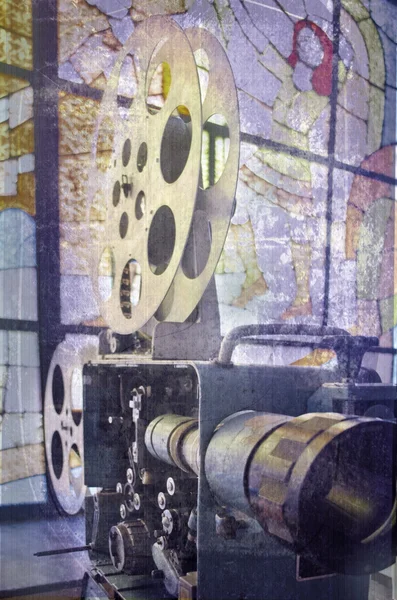 Old and antique commercial movie projector on a background of stained glass. Mechanism of the aged theater projector.