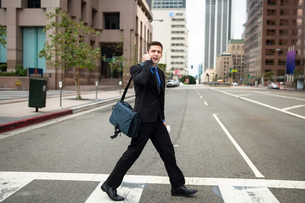 Business man executive crossing the street on the way to work late for appointment