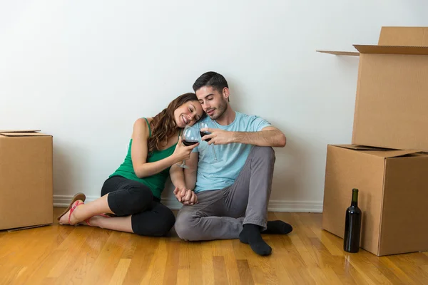 Married couple move into their first house together and celebrate with glass bottle of red wine